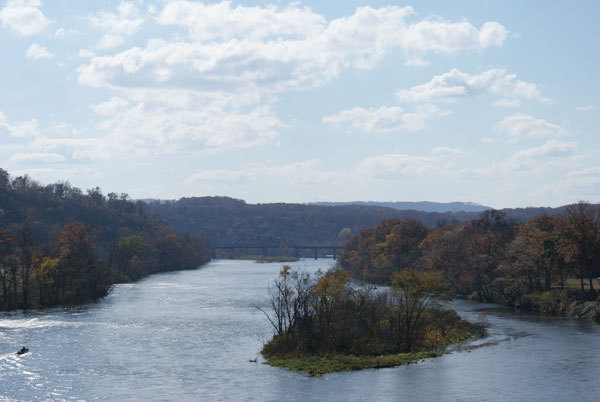 Landscape along both edges of the river featuring a bridge in the background.