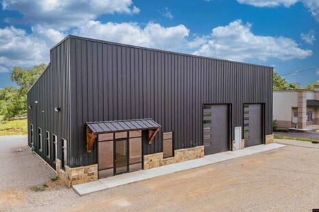 A grey commercial building with two garage doors.