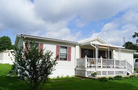 A white double wide with a covered front porch.