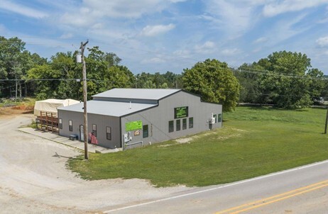 A big grey building next to a road. 