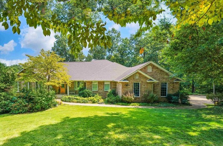 A big grass yard leading to a big brick house.